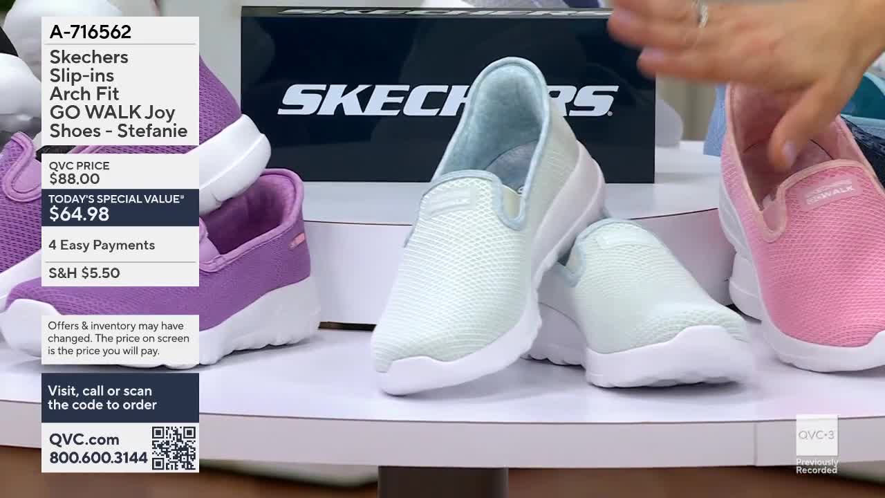 A hand reaches in to adjust a pink Skechers slip-on shoe on display. Nearby, a pale blue shoe rests on a white sole, its mesh fabric catching the light.