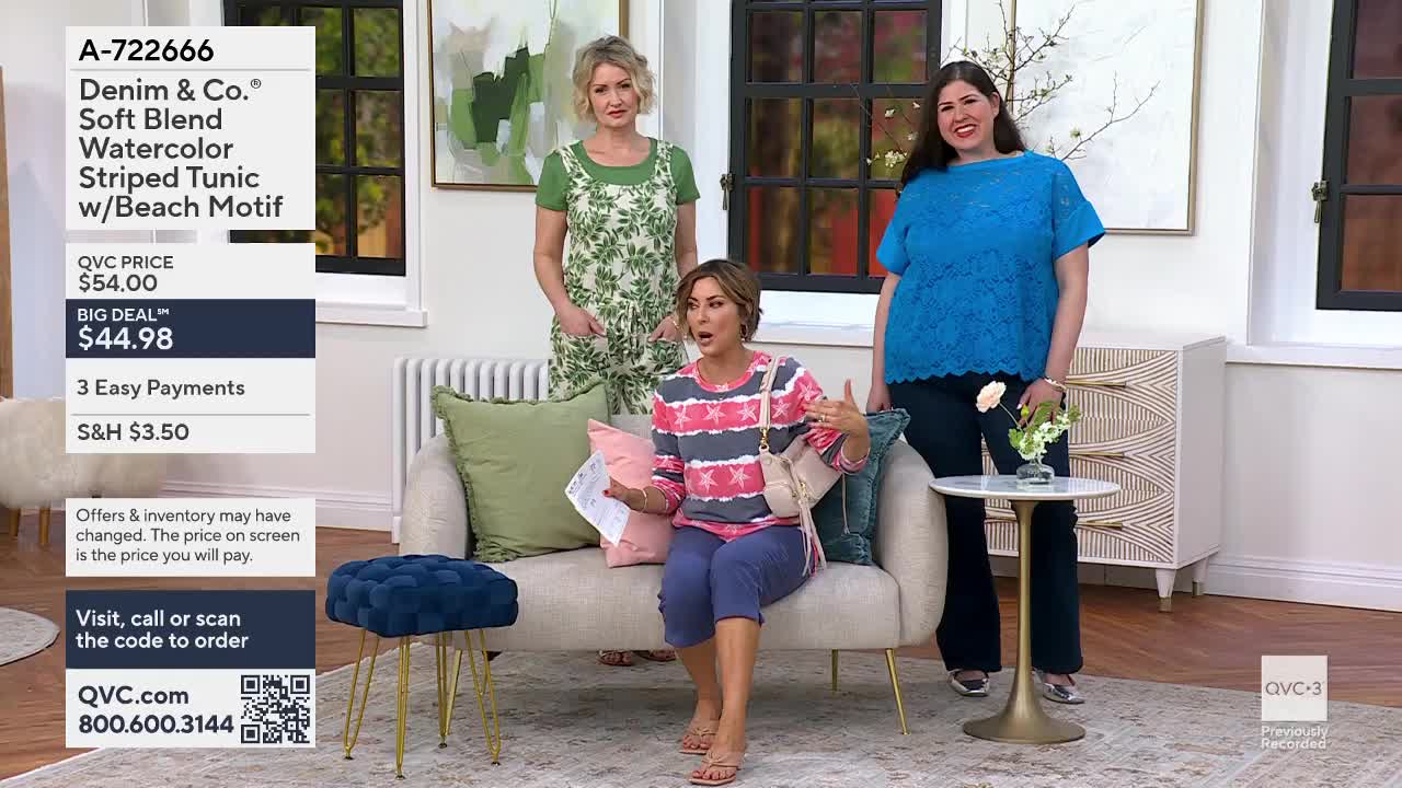A woman in a pink and gray striped top gestures animatedly from a couch. Another woman in a bright blue lace top stands beside a small table, holding a bouquet of white flowers. A third woman, wearing a green floral print outfit, stands behind them.