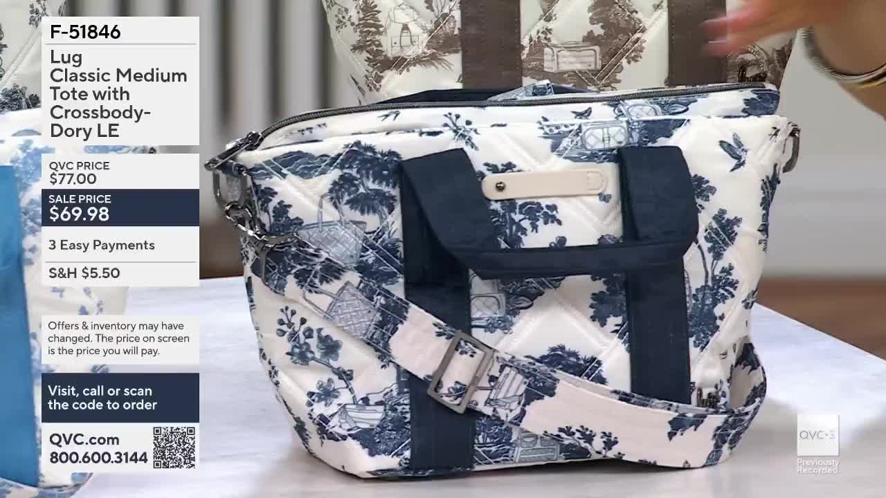 A hand reaches in from the right, adjusting the strap of a quilted tote bag. The bag displays a blue and white toile pattern with scenes of countryside life.