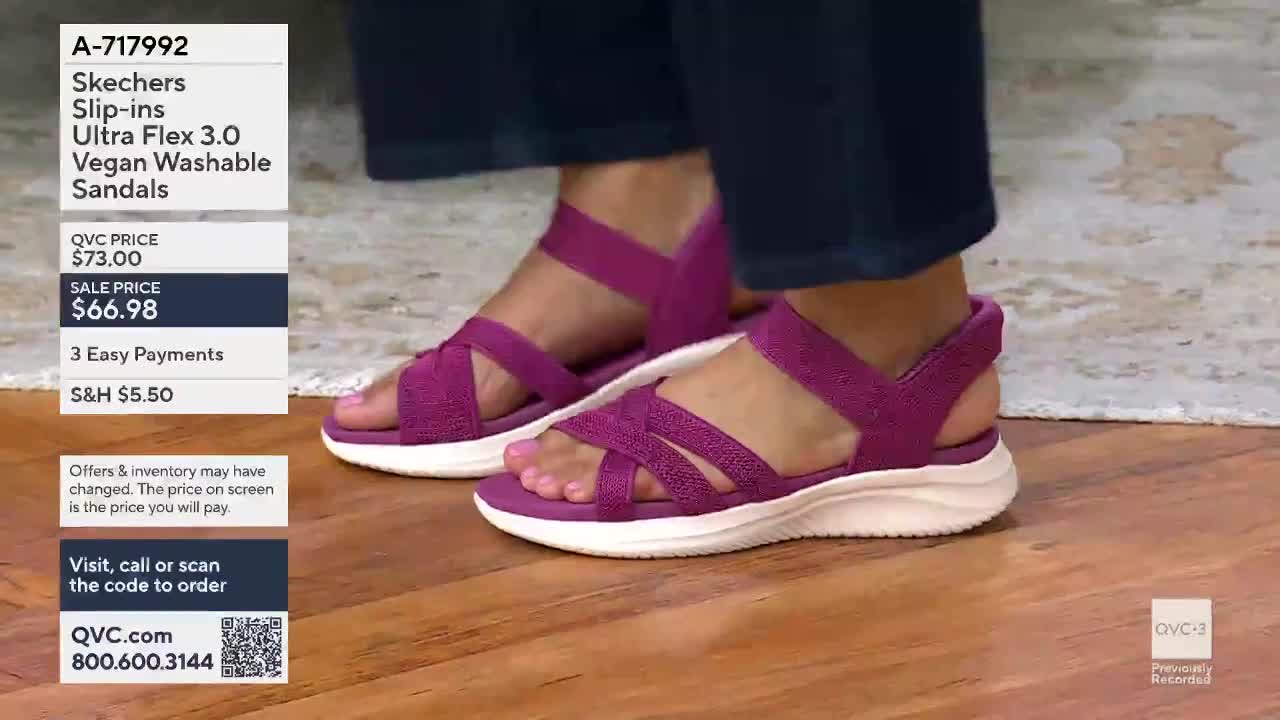 A pair of magenta Skechers sandals with crisscrossed straps rests on a wooden floor. The shoes are on display with pricing information for QVC.