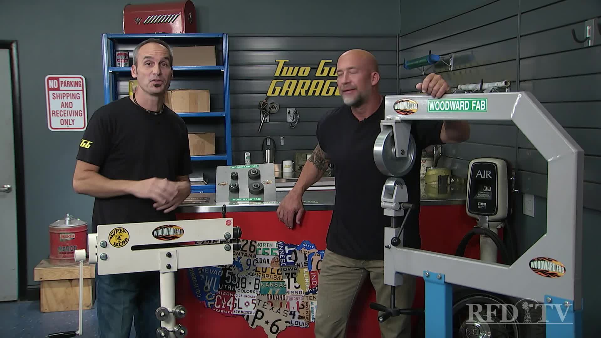 Two men stand in a garage, each next to a large metalworking machine. They're on the set of RFD-TV's "Two Guys Garage," ready to demonstrate some tools.
