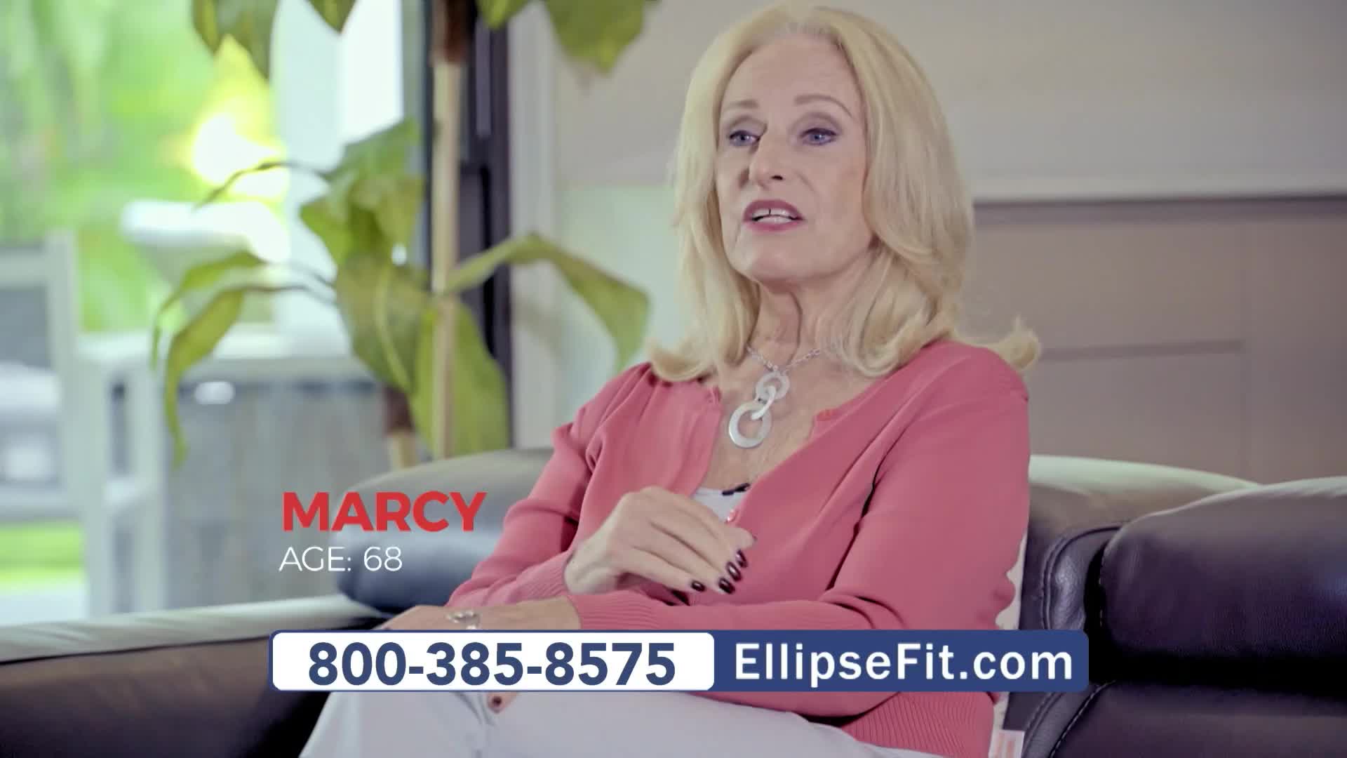 Marcy, age 68, is speaking, her hands gesturing as she sits on a black leather couch. The RFD-TV ad for EllipseFit includes a phone number and website address on the screen.
