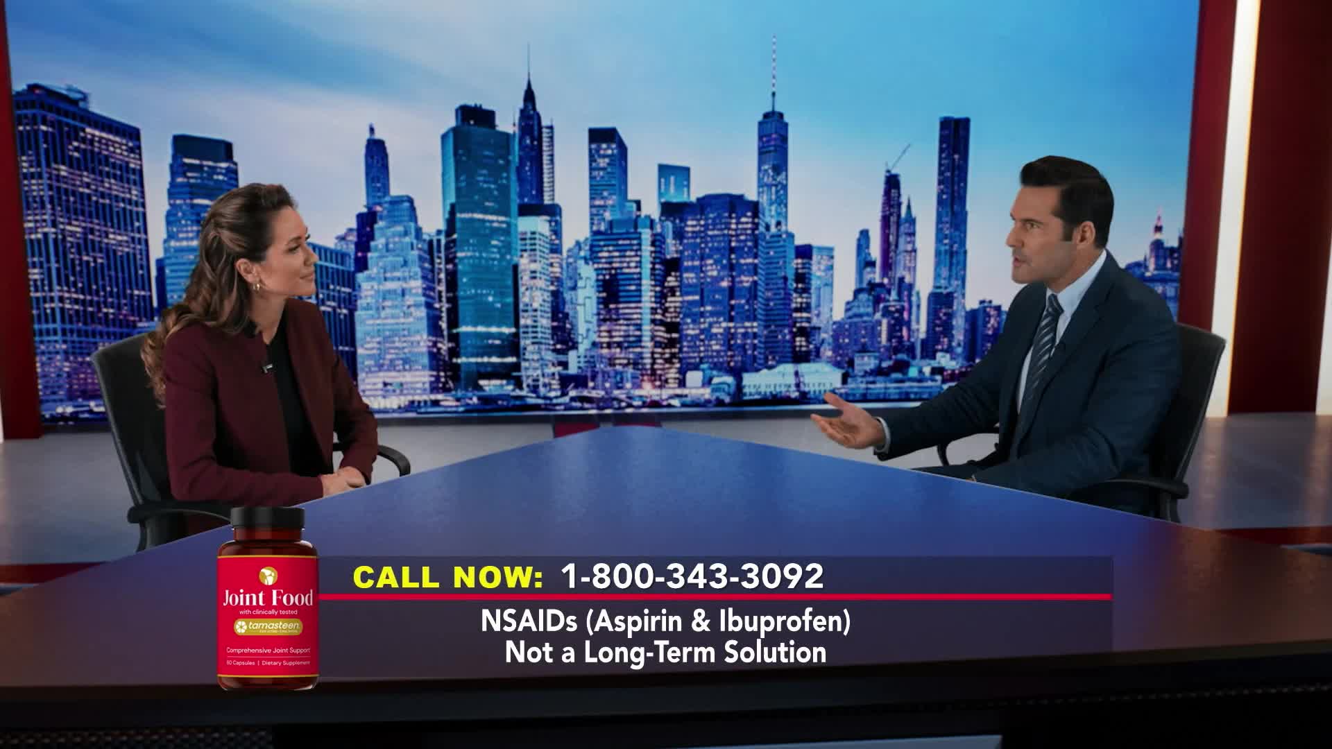 A man in a suit gestures toward a woman, both seated at a table with a city backdrop. A commercial for "Joint Food" is displayed on the screen, with a phone number and a warning about NSAIDs.
