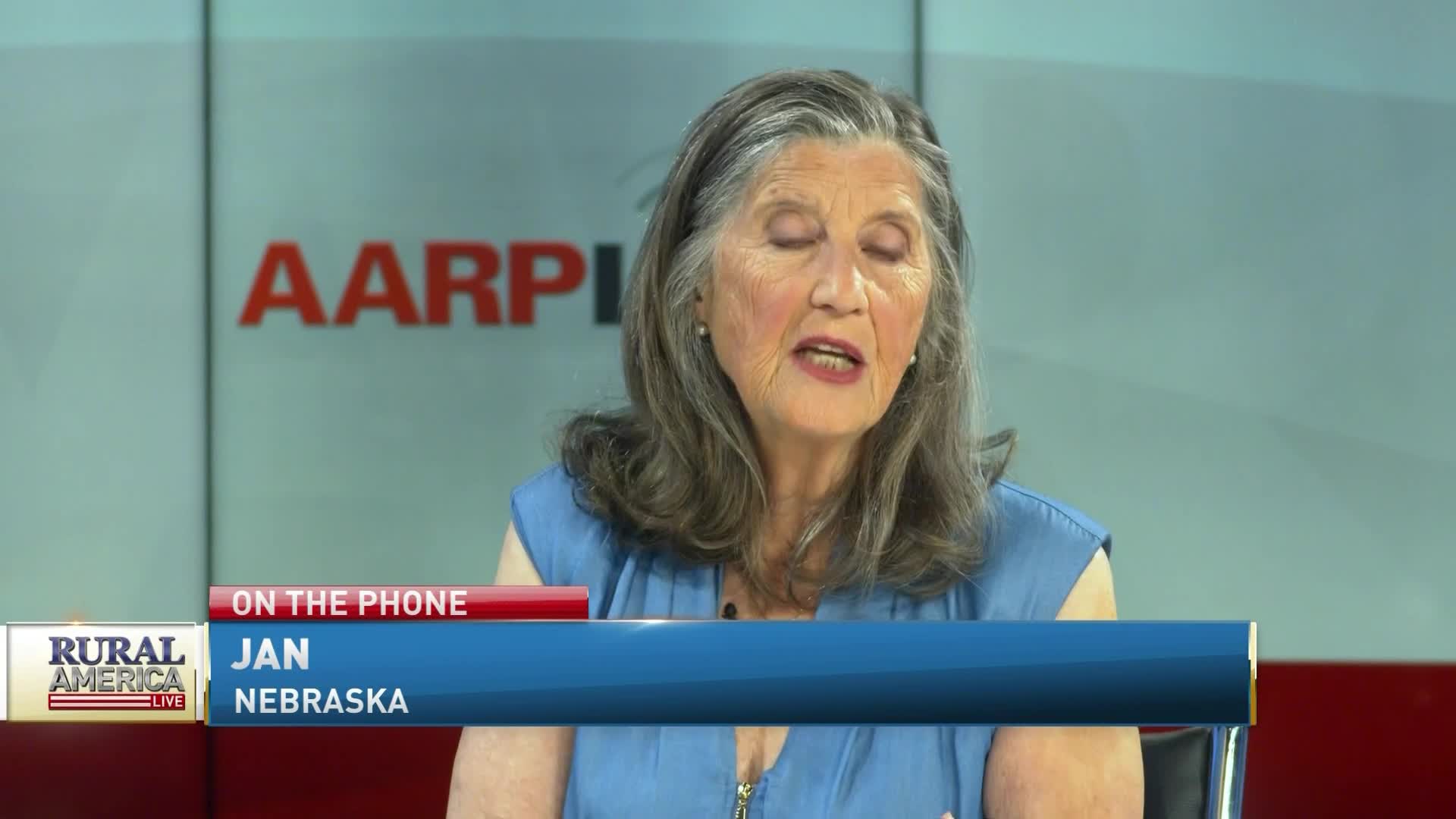 On RFD-TV's "Rural America Live," a woman named Jan from Nebraska is speaking, her face framed by graying hair. The AARP logo is visible behind her as she talks on the phone.
