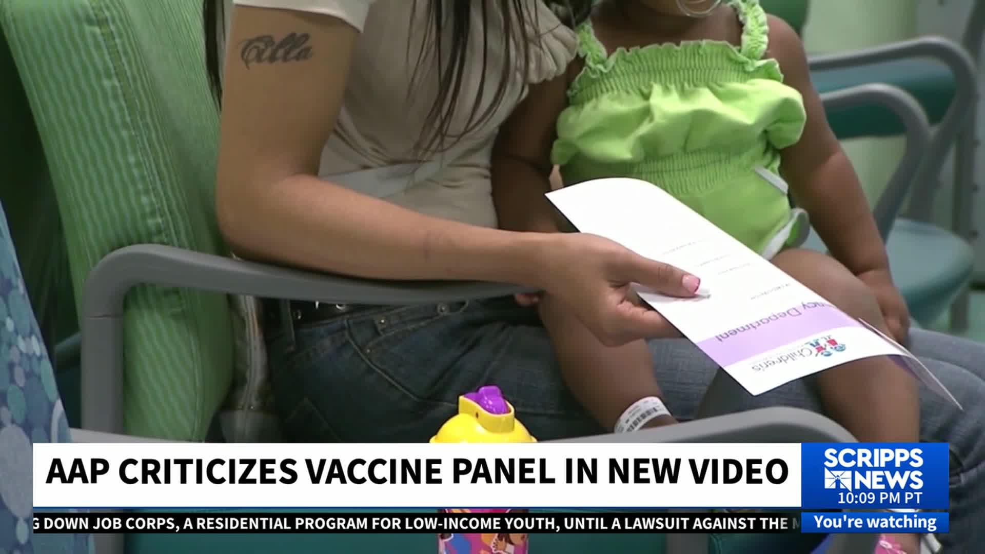 A woman holds a document, likely from a children's hospital, while a young child sits on her lap. The Scripps News logo in the corner indicates this scene is part of a news segment in the United States.
