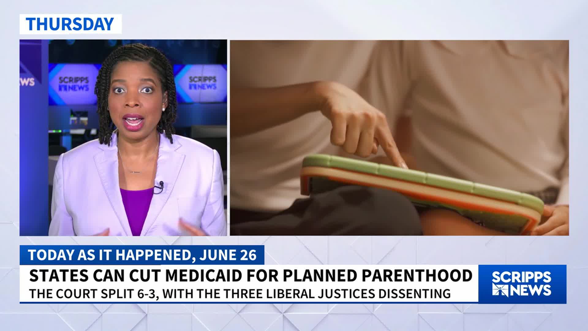 A news anchor from Scripps News in the United States is speaking, her expression animated. Beside her, a hand gestures toward a colorful object, perhaps a toy.
