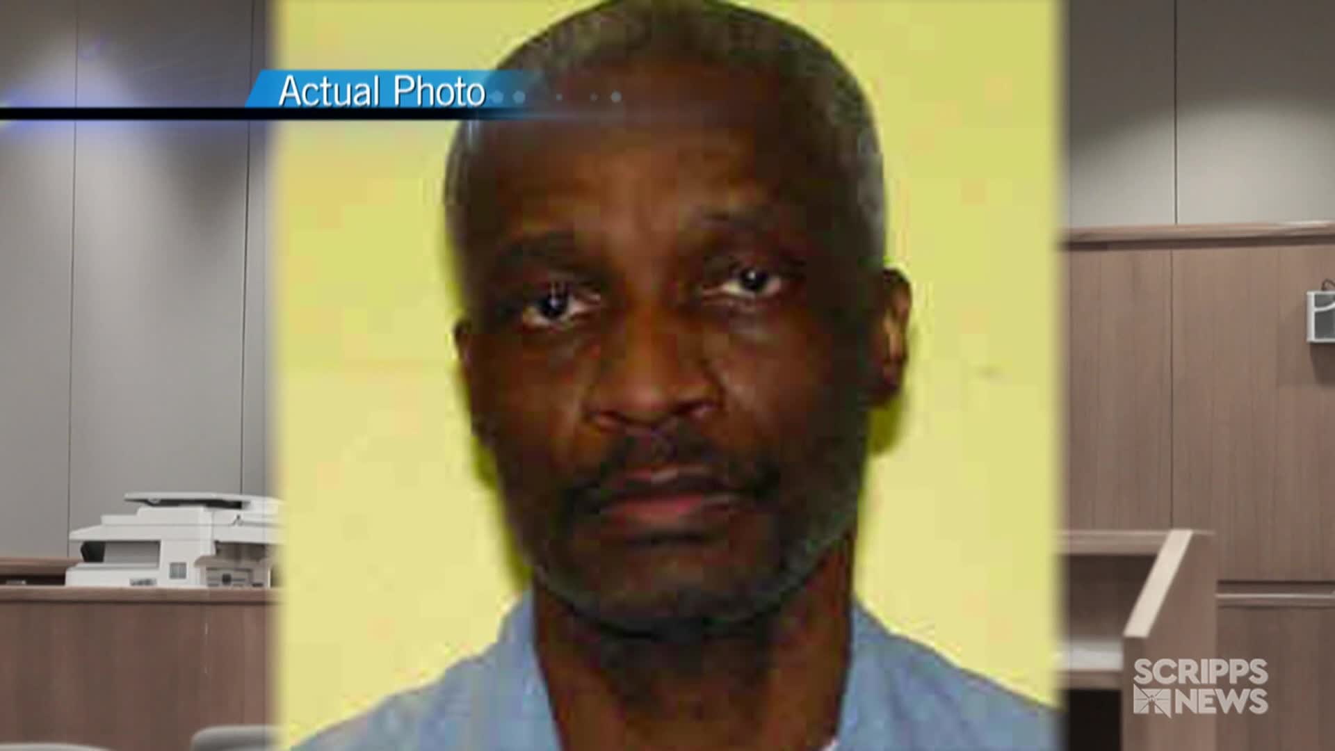 A man with a close-cropped haircut and a mustache is centered in the frame, his gaze directed forward. The "Actual Photo" label and Scripps News logo suggest this is part of a news report in the United States.
