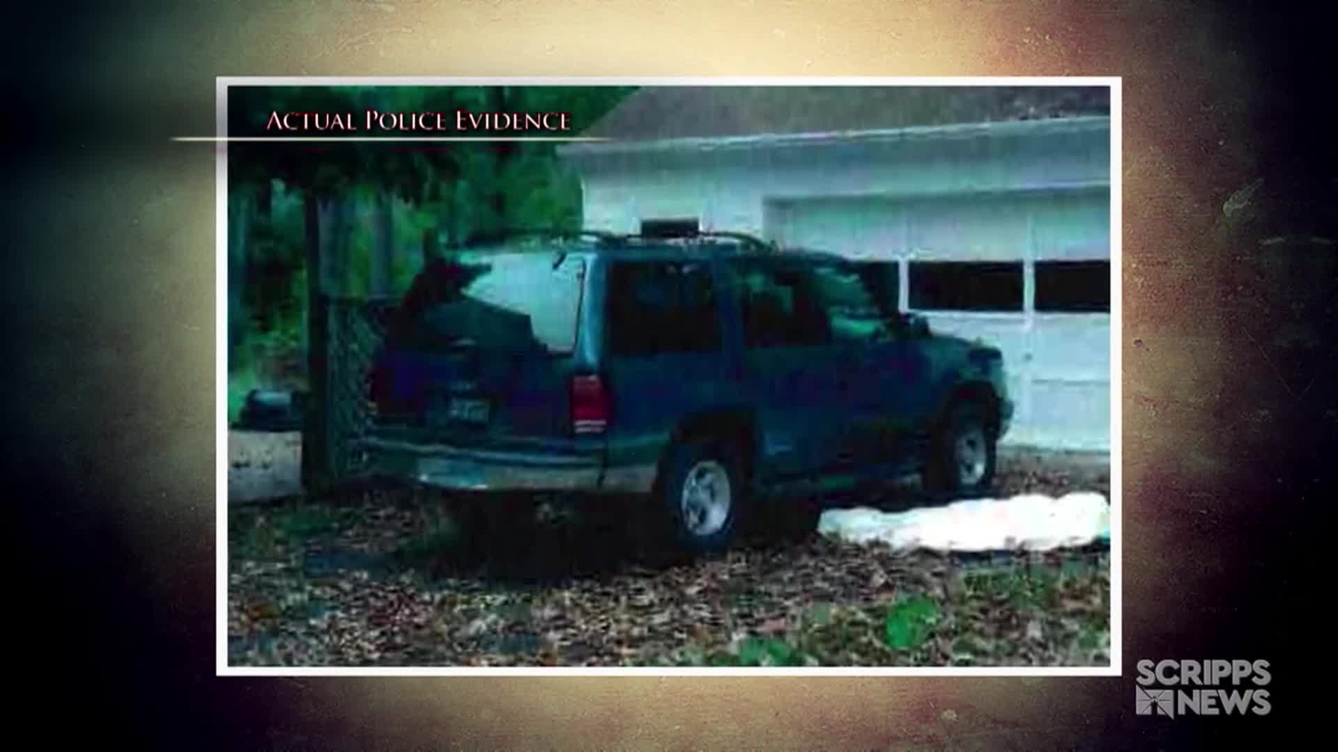 A dark blue SUV sits parked in front of a garage, its rear end facing the camera.  The image, labeled "Actual Police Evidence," is framed by a Scripps News graphic.
