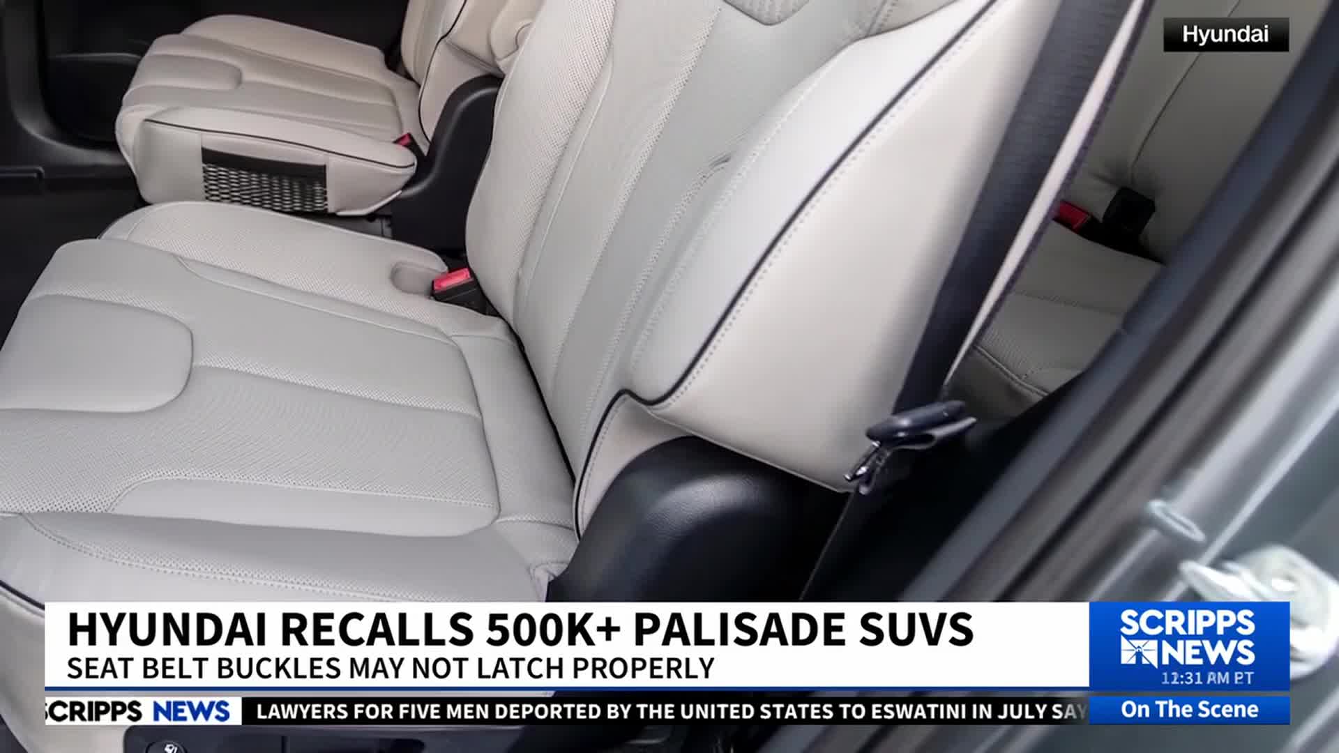 Inside a Hyundai, light-colored leather seats are visible, and a seat belt buckle hangs loose. A Scripps News graphic reports on a recall of over 500,000 Palisade SUVs in the United States.
