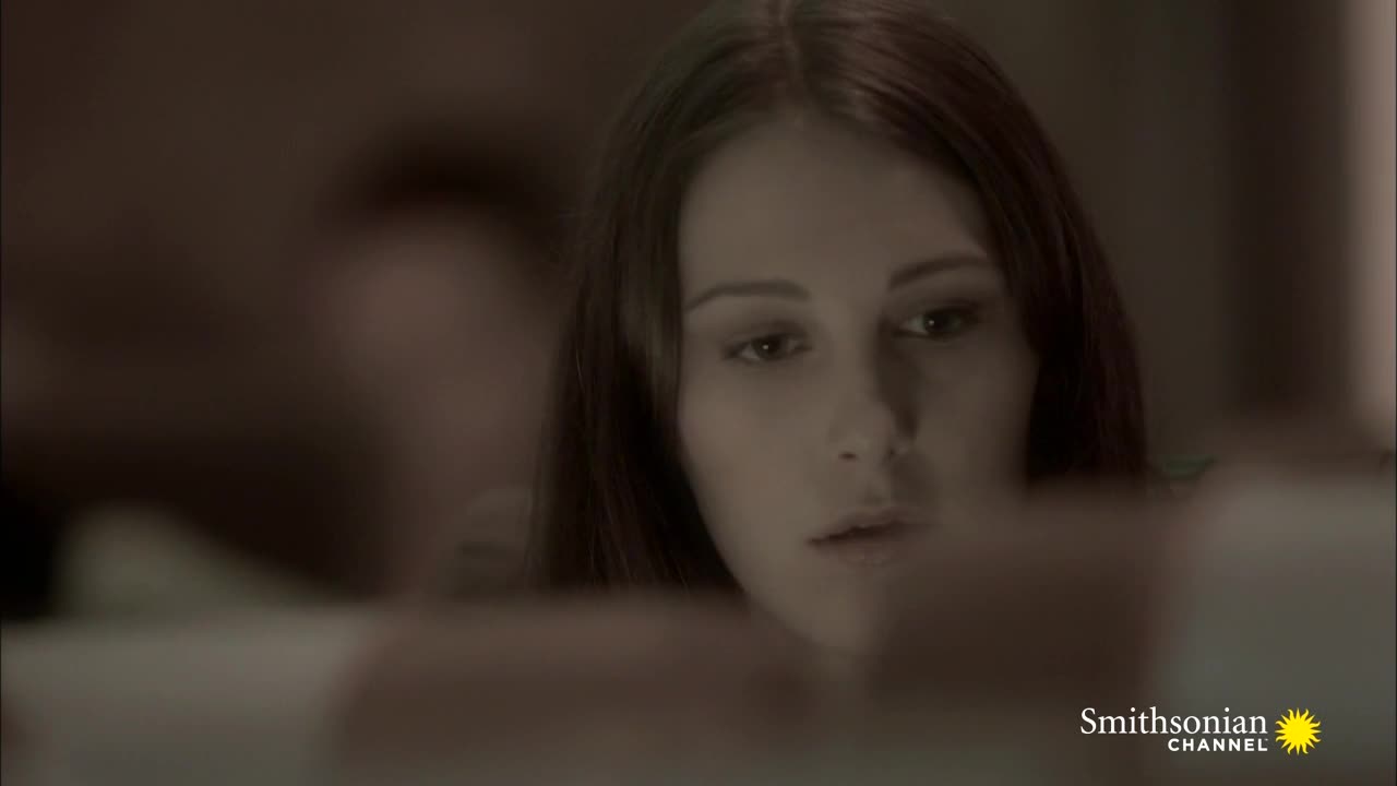 A woman with long brown hair is looking down, her expression a mix of concentration and concern. The Smithsonian Channel logo is in the corner, suggesting this is a scene from a documentary or program.
