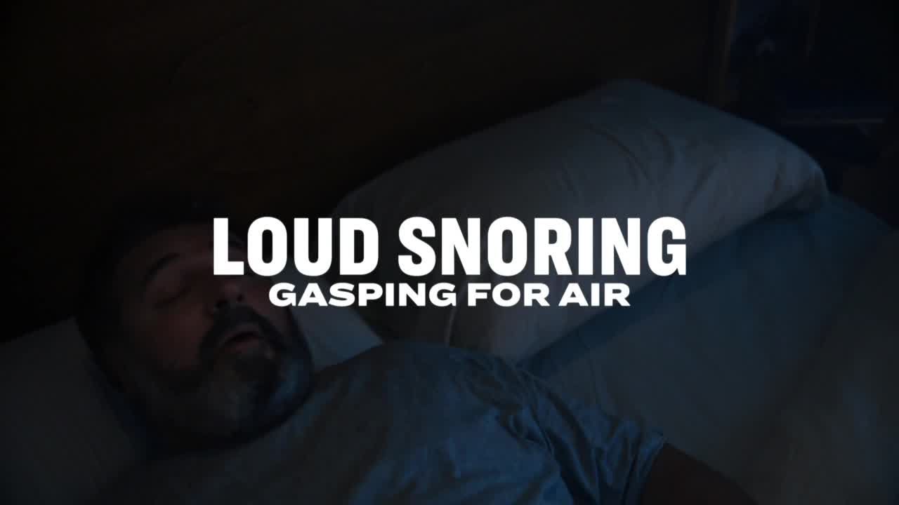 A man lies asleep, his mouth slightly open on a pillow. Above him, the words "Loud Snoring, Gasping for Air" are displayed.
