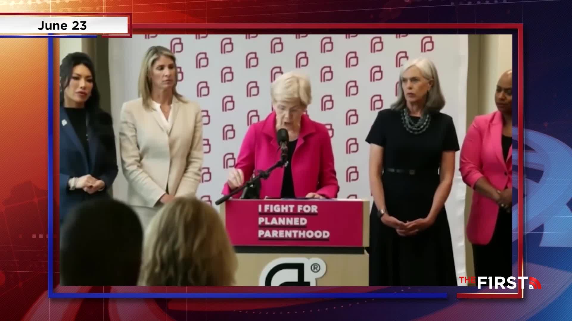 A woman in a bright pink blazer speaks from a podium, the words "I FIGHT FOR PLANNED PARENTHOOD" visible.  Flanking her are other women, all standing still, as the scene is broadcast on The First TV.
