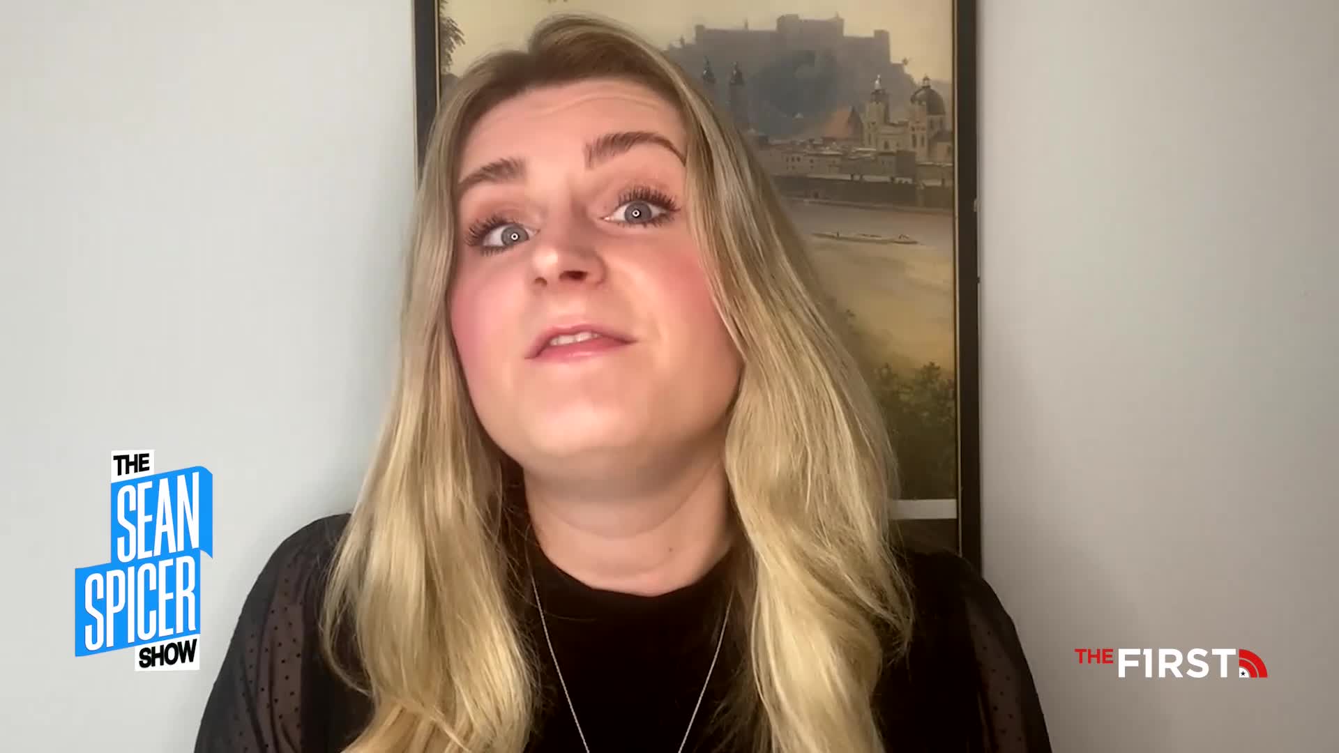 A woman with long blonde hair is looking directly at the camera, speaking on a set for The Sean Spicer Show on The First TV. The background includes a framed picture and a plain white wall.
A woman with long blonde hair is looking directly at the camera, speaking on a set for The Sean Spicer Show on The First TV. The background includes a framed picture and a plain white wall.