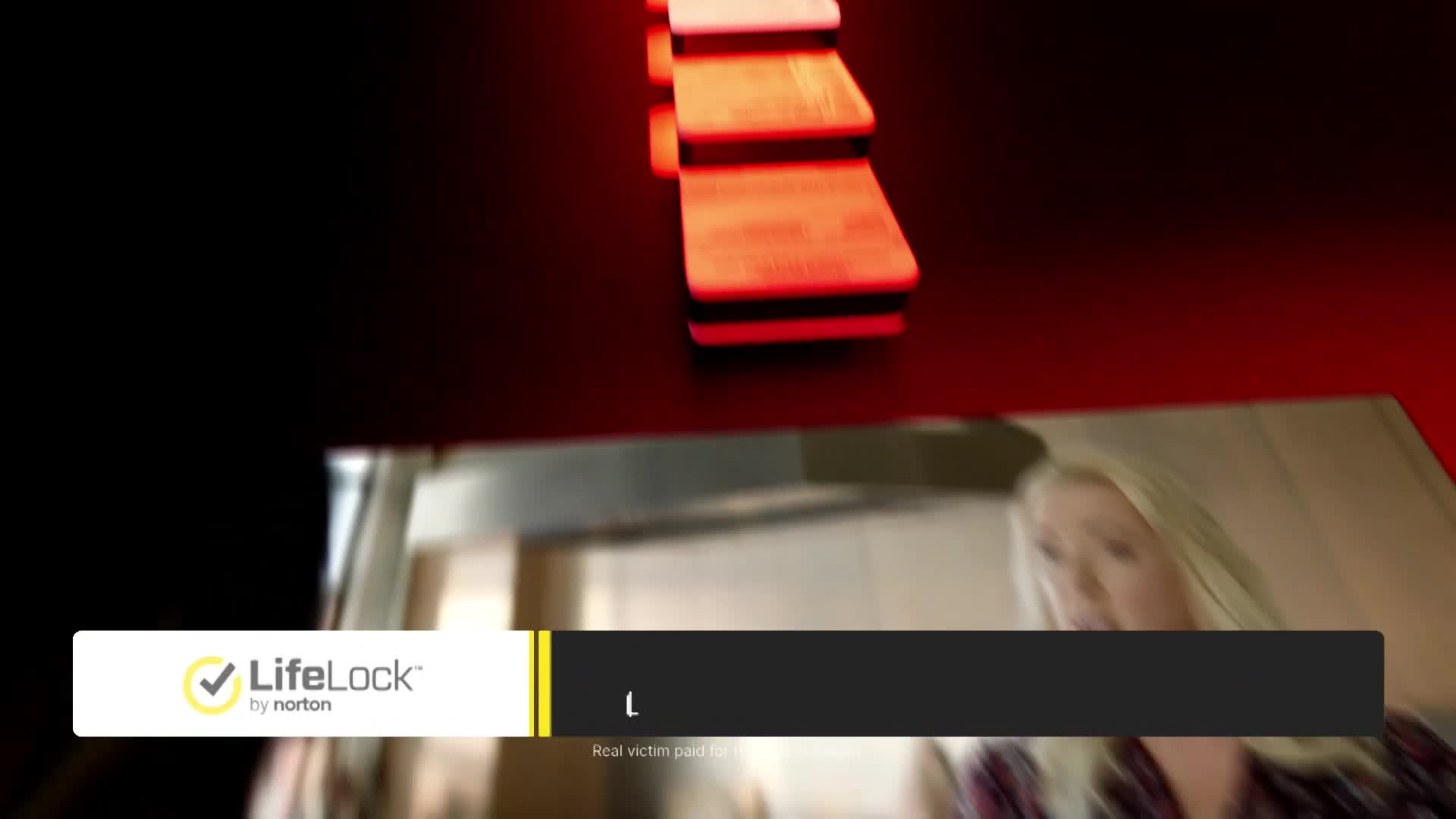 A woman with blonde hair moves quickly through a room. Above her, red-lit blocks fall in a line.