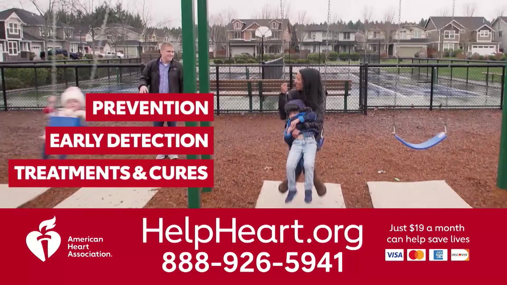 A man stands by a swing set, watching a child in mid-air. A woman holds a child, both jumping on a mat.