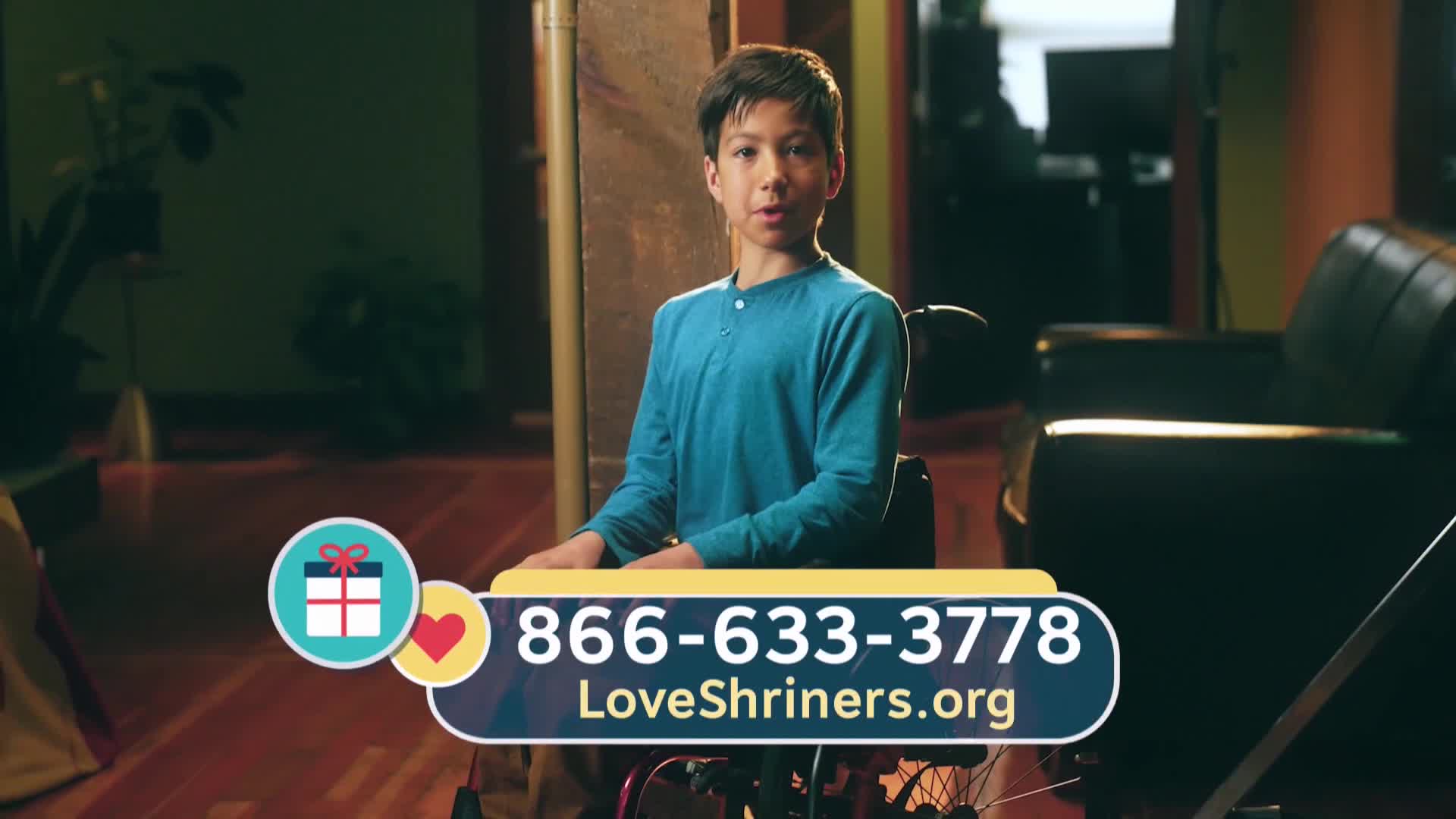 A young boy in a wheelchair speaks directly to the camera. A phone number and website appear on screen.