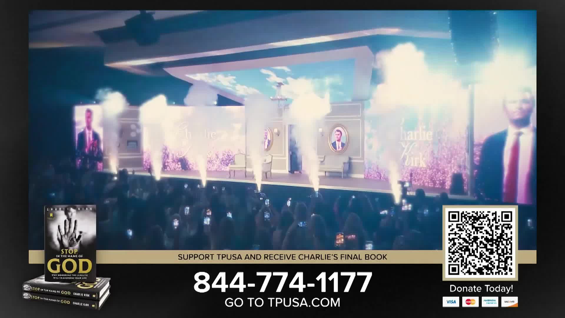 Smoke plumes erupt from the stage as a speaker addresses the crowd. Phones are held high, capturing the moment.