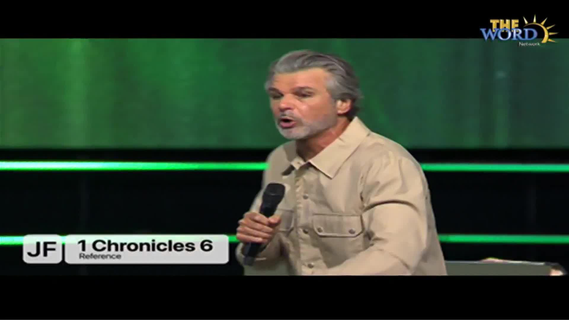A man with silver hair and a tan shirt speaks into a microphone on a stage. The Word Network logo is visible in the top right corner, and a reference to 1 Chronicles 6 appears at the bottom.
