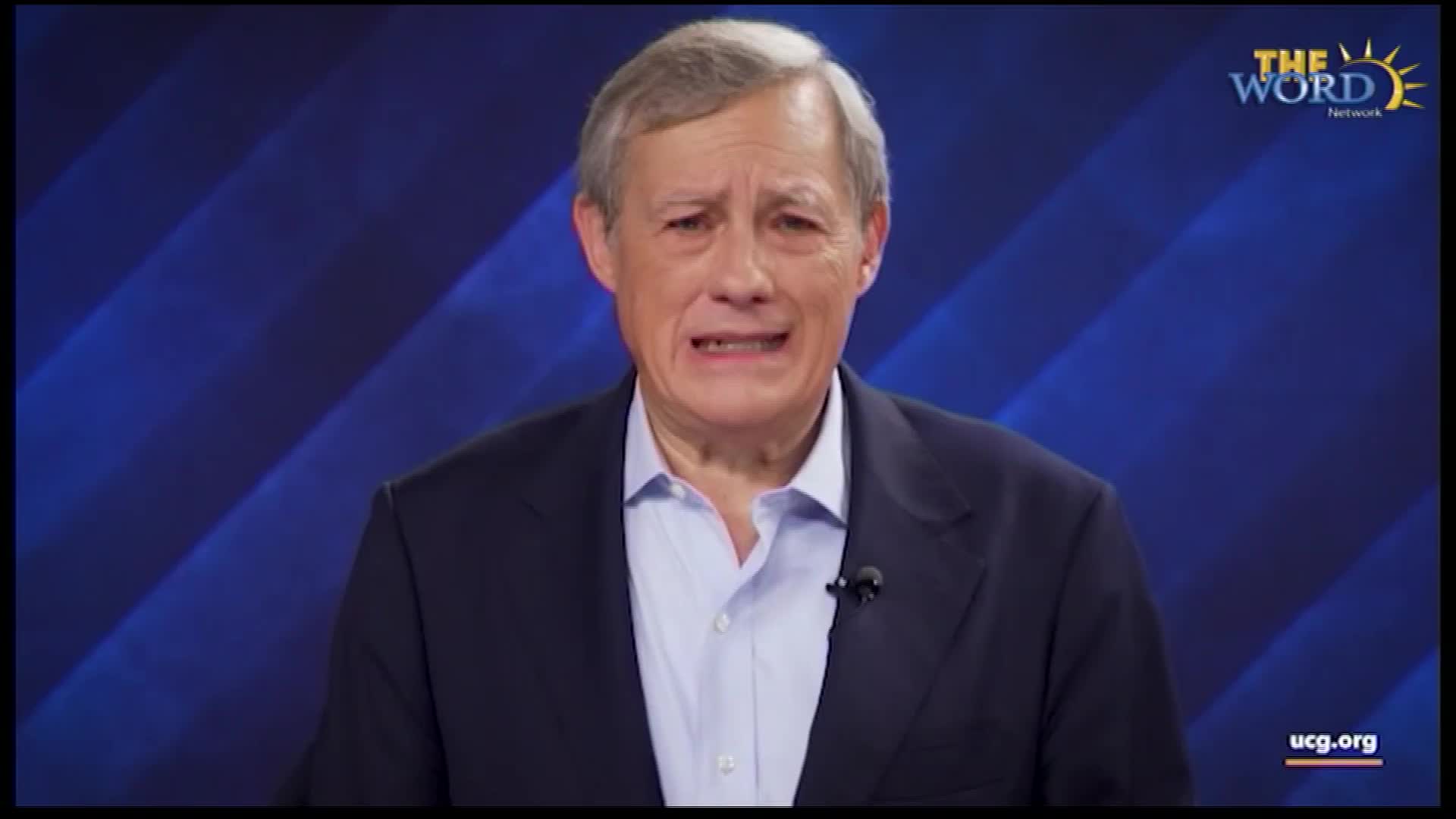 A man in a dark suit and light blue shirt is speaking, looking directly at the camera. The Word Network logo is visible in the upper right corner.
