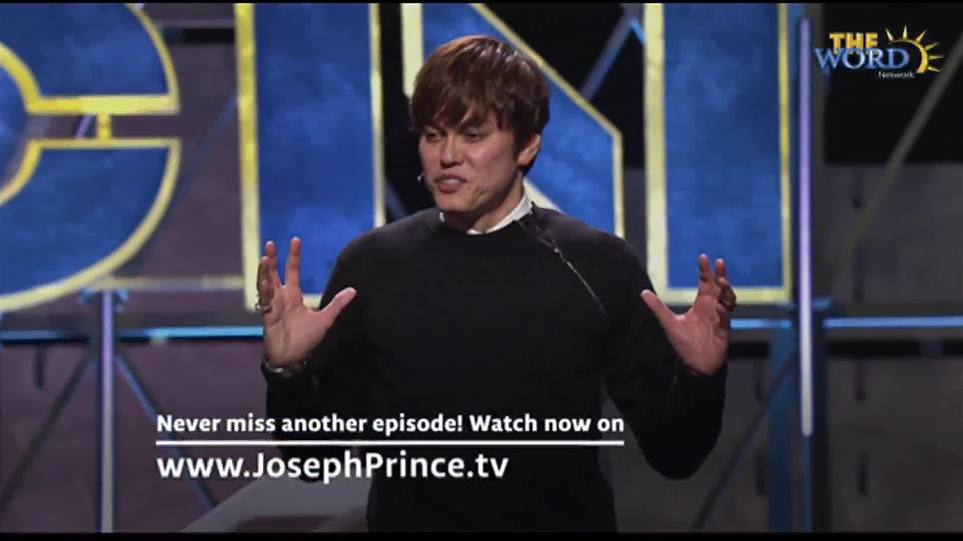 The man on stage, framed by a backdrop, gestures with both hands. He's speaking, and the logo for The Word Network is visible in the corner.
