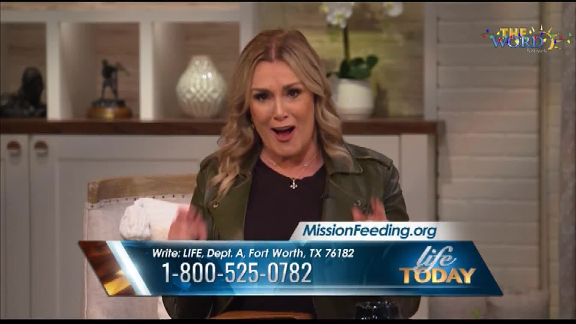 A woman with blonde hair gestures with her hands, speaking animatedly on a television set. The screen displays a phone number and address for "MissionFeeding.org" with "life TODAY" branding, and the logo of The Word Network is visible in the corner.
