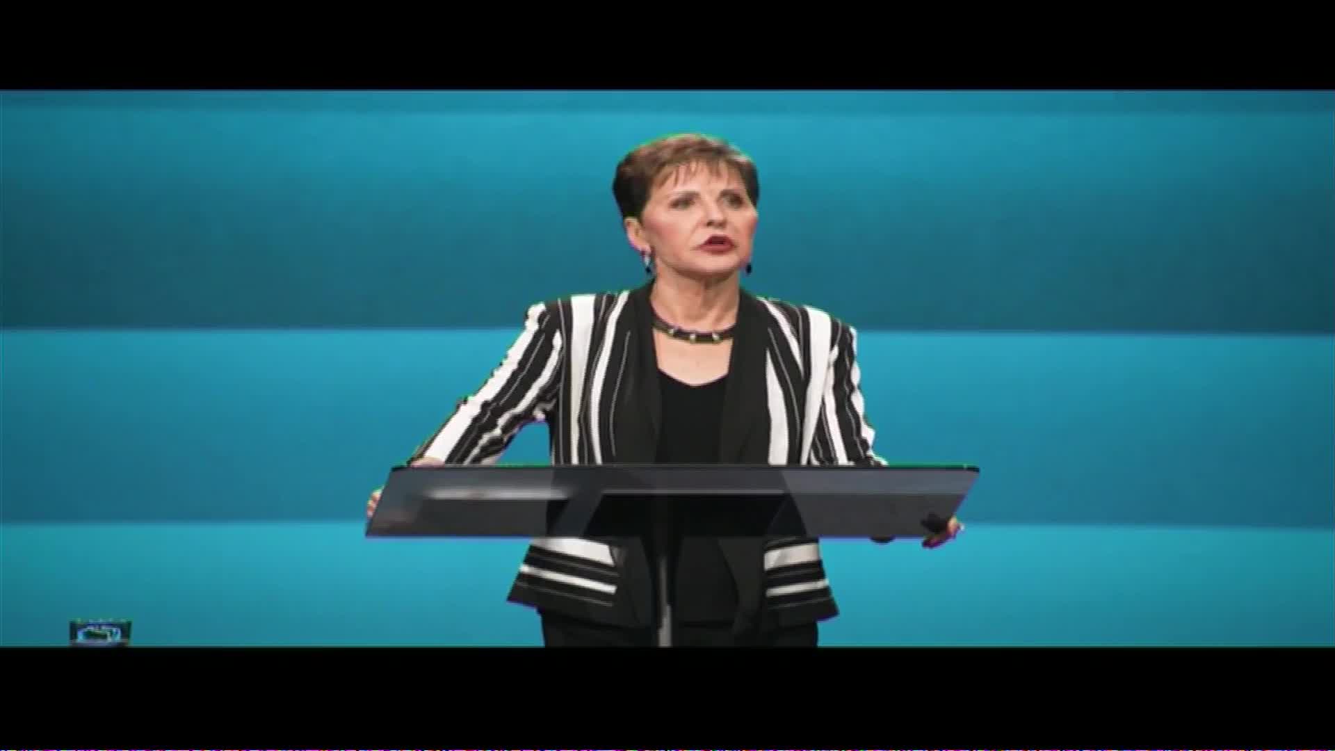 A woman in a black and white striped jacket stands behind a lectern, speaking. The backdrop is a series of horizontal blue bands. This appears to be a broadcast from The Word Network in the United States.