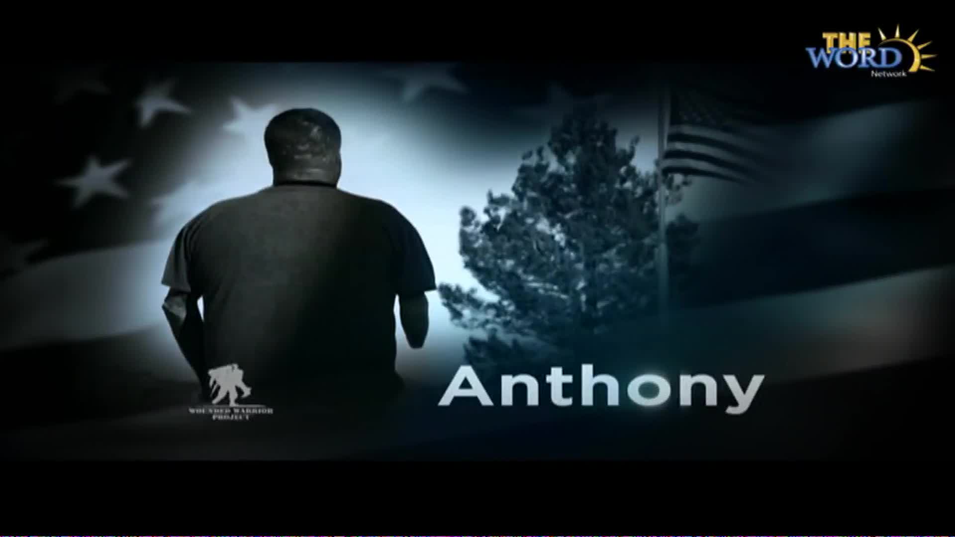 Anthony stands with his back to me, his silhouette stark against the American flag. A logo for The Word Network appears in the corner, and beneath him, the words "Wounded Warrior Project" are visible.