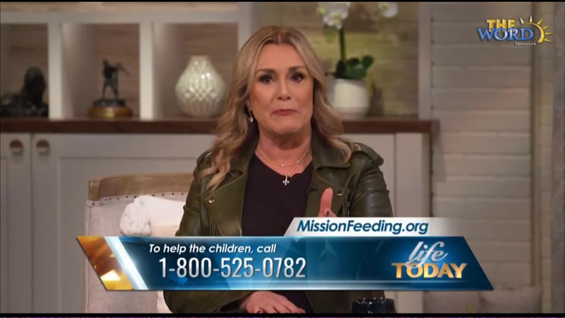 A woman speaks directly to the camera, her hand raised in emphasis.  A graphic overlay displays a phone number and website for MissionFeeding.org.