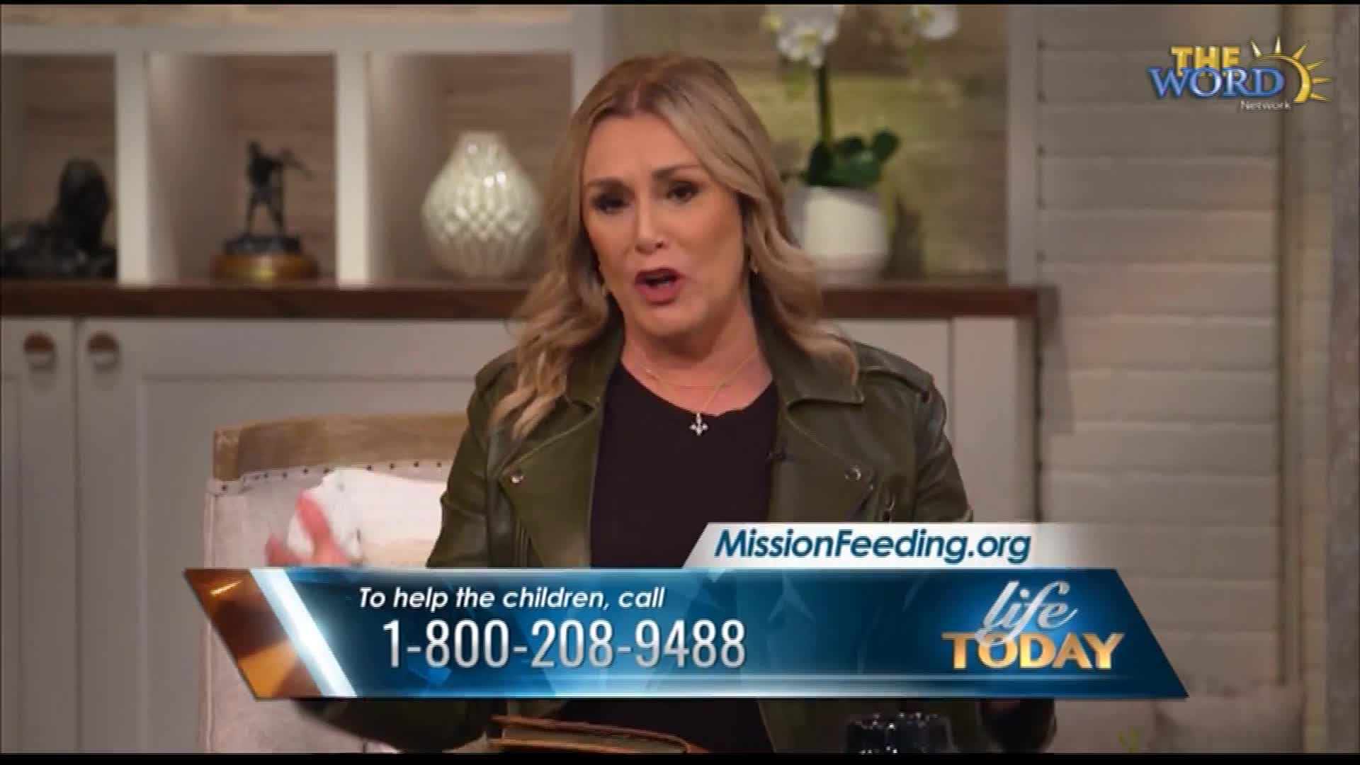 A woman speaks on a television program, her words appearing on a graphic overlay. The graphic displays a website, MissionFeeding.org, and a phone number to help children. The Word Network logo is visible in the upper right corner.