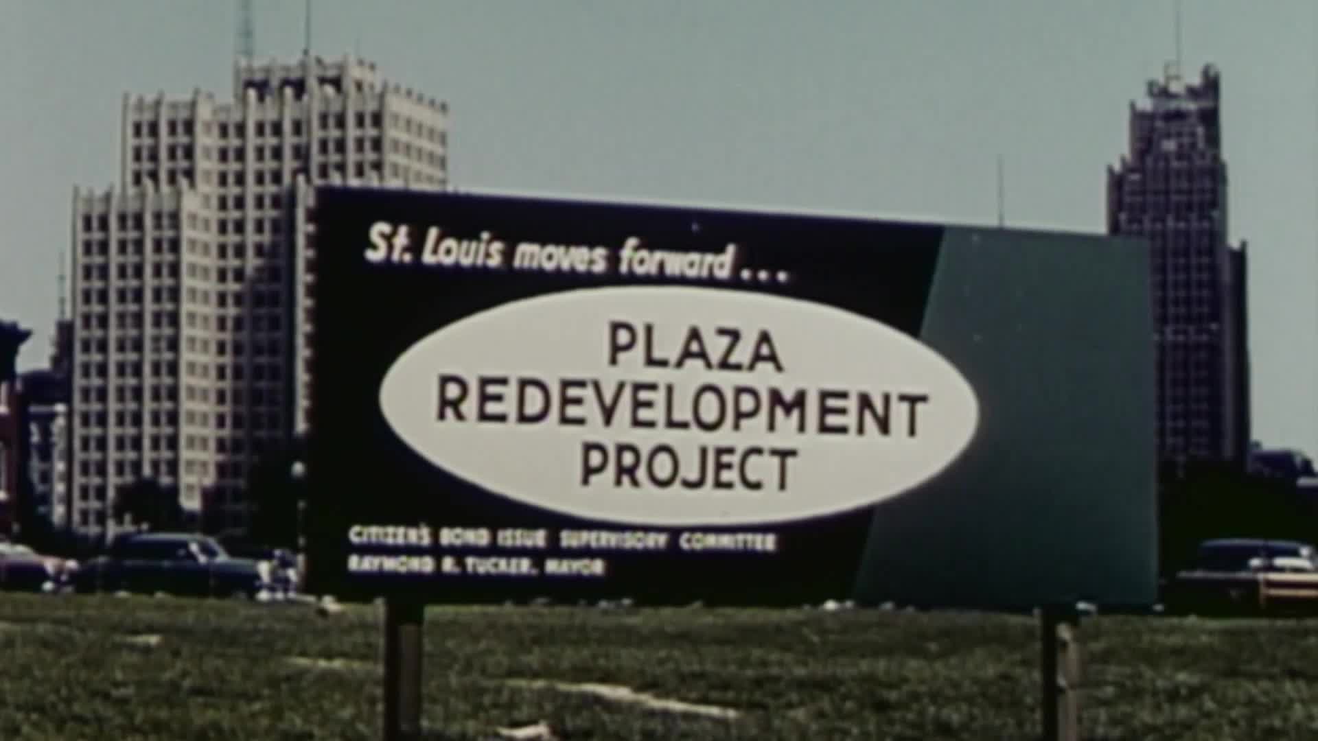 A roadside sign touts the "Plaza Redevelopment Project" in St. Louis, with a backdrop of towering buildings and a few parked cars. The sign's design and the cars' style suggest a mid-20th century setting, possibly from a VICE TV documentary.
A roadside sign touts the "Plaza Redevelopment Project" in St. Louis, with a backdrop of towering buildings and a few parked cars. The sign's design and the cars' style suggest a mid-20th century setting, possibly from a VICE TV documentary.