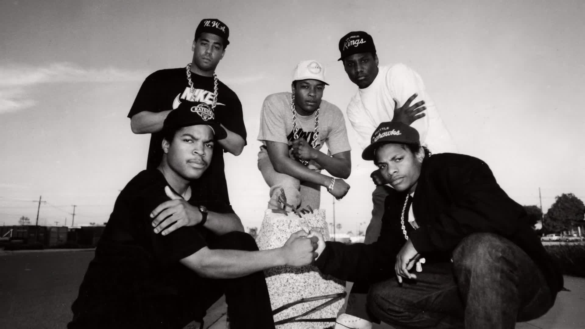 Five young men, wearing baseball caps and heavy chains, pose for a photo. Two of them are bumping fists, a gesture of solidarity that feels like it could be for a VICE TV segment.