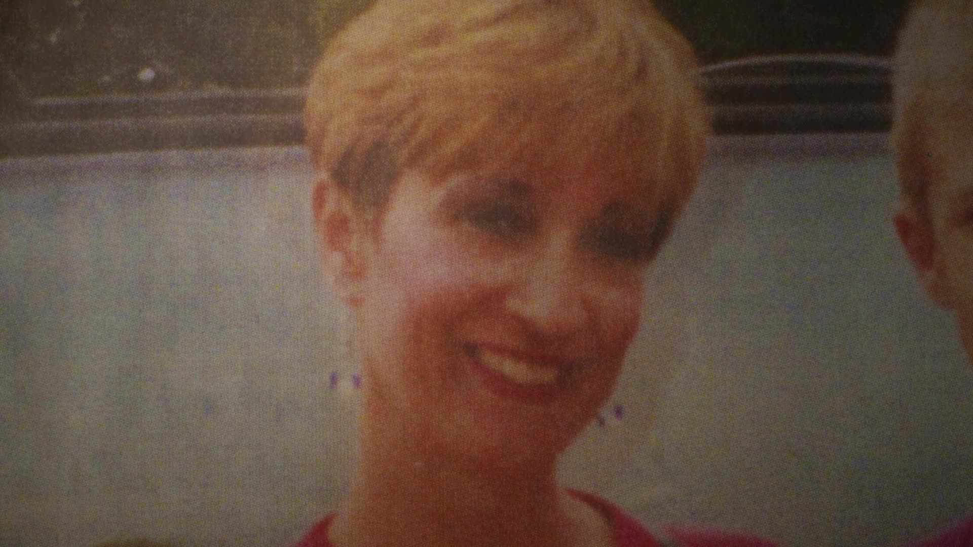 A woman with short, blonde hair smiles directly at me, her eyes sparkling. To her right, another person's face is partially visible, also looking forward.