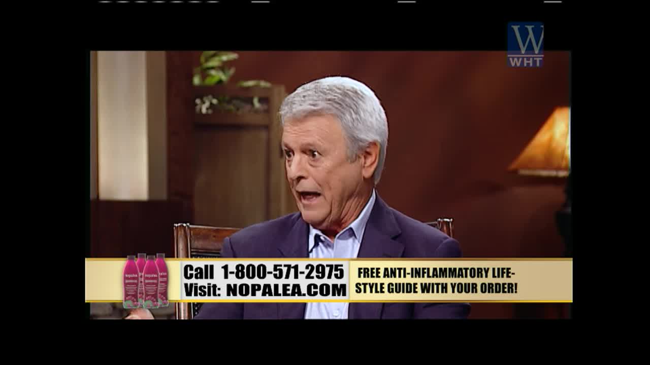 The man in the suit is talking, his mouth open as if making a point on World Harvest TV. A banner at the bottom of the screen advertises a product and a phone number.
