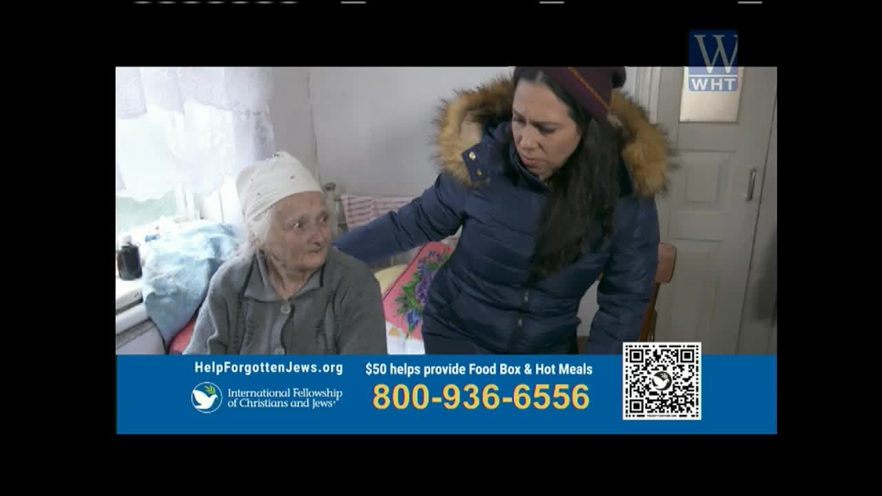 A woman in a winter coat leans toward an elderly woman seated near a window. The scene is part of a segment on World Harvest TV, promoting aid to "Forgotten Jews."
