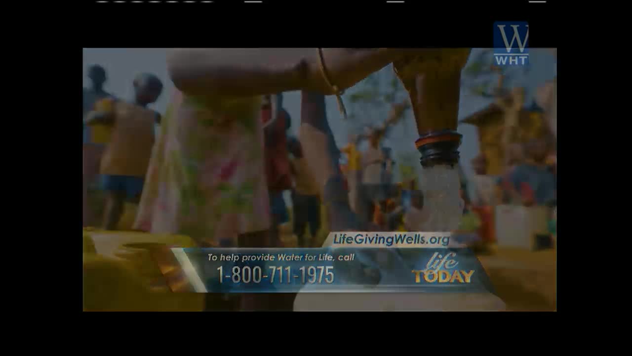 Water streams steadily from a spout into a clear bottle, held by a person whose arm is visible. Children and adults stand nearby, and the scene is framed by a World Harvest TV graphic promoting a water charity.
