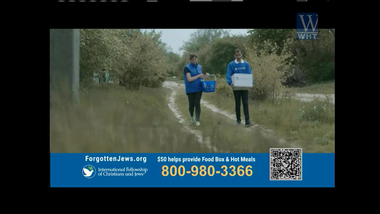 Two people walk along a dirt path, one carrying a box and the other a basket, likely delivering supplies. The scene is part of an advertisement on World Harvest TV, promoting aid through the International Fellowship of Christians and Jews.
