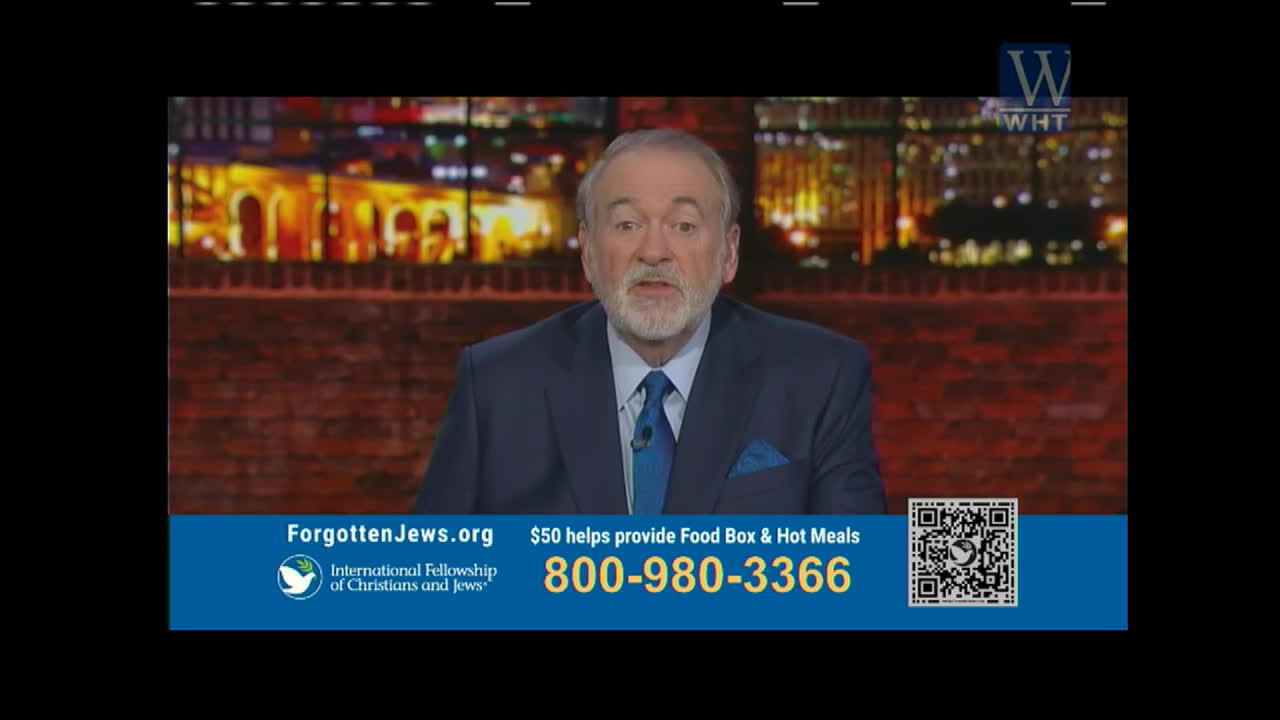 A man in a blue suit speaks directly to the camera against a backdrop of a city at night, likely on World Harvest TV. Below, a banner advertises a phone number and a website for the International Fellowship of Christians and Jews.
