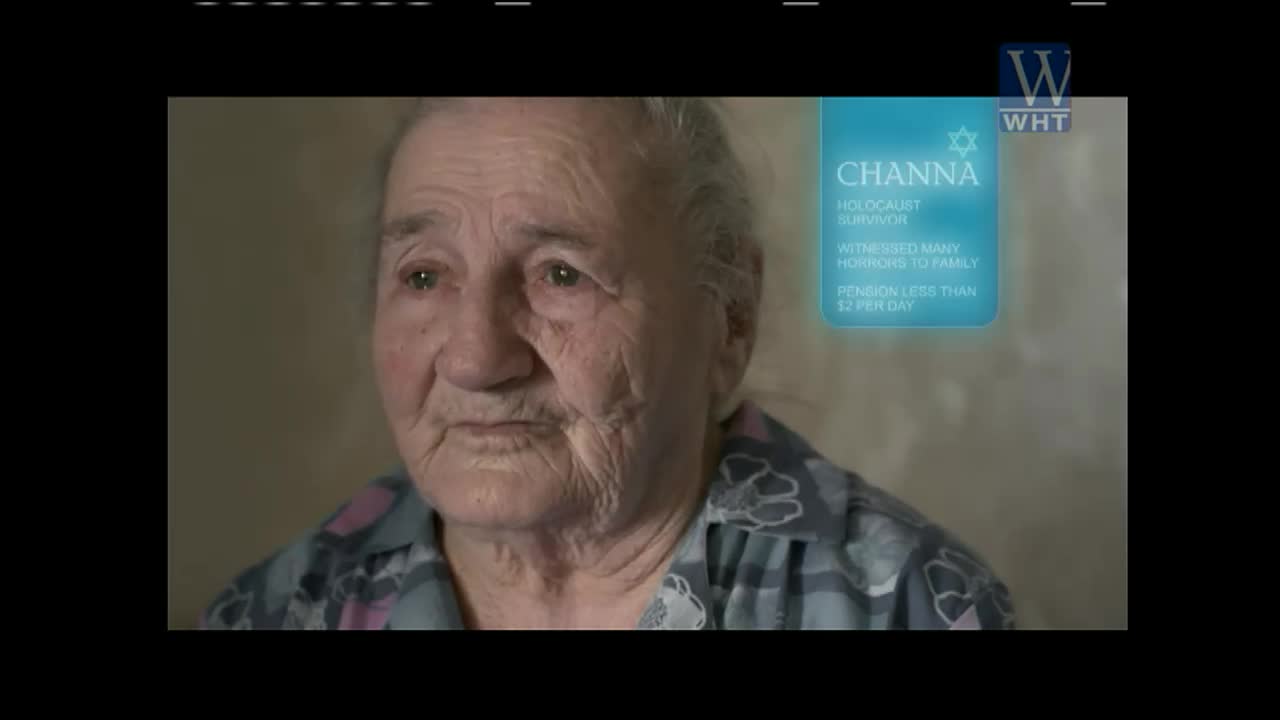 An elderly woman, identified as Channa on a World Harvest TV graphic, stares directly ahead. Her face is etched with age and sorrow.
