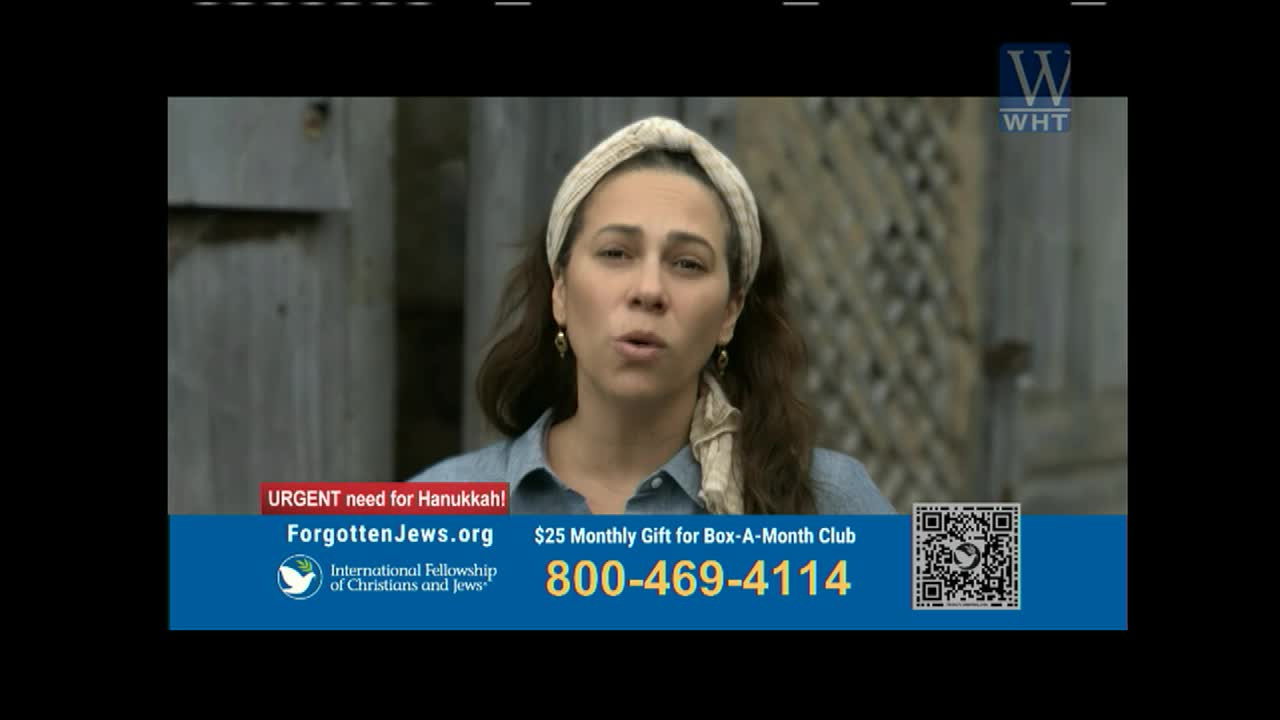 A woman with a scarf on her head speaks directly to the camera, her mouth open as if mid-sentence. Beneath her, a blue banner on World Harvest TV urges viewers to donate for Hanukkah.
