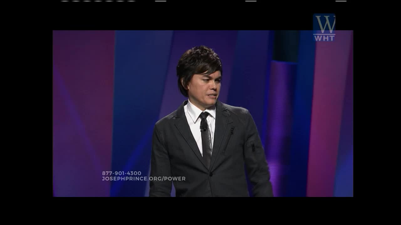 A man in a dark suit stands on a stage, speaking to an unseen audience. The World Harvest Television logo appears in the upper right corner.