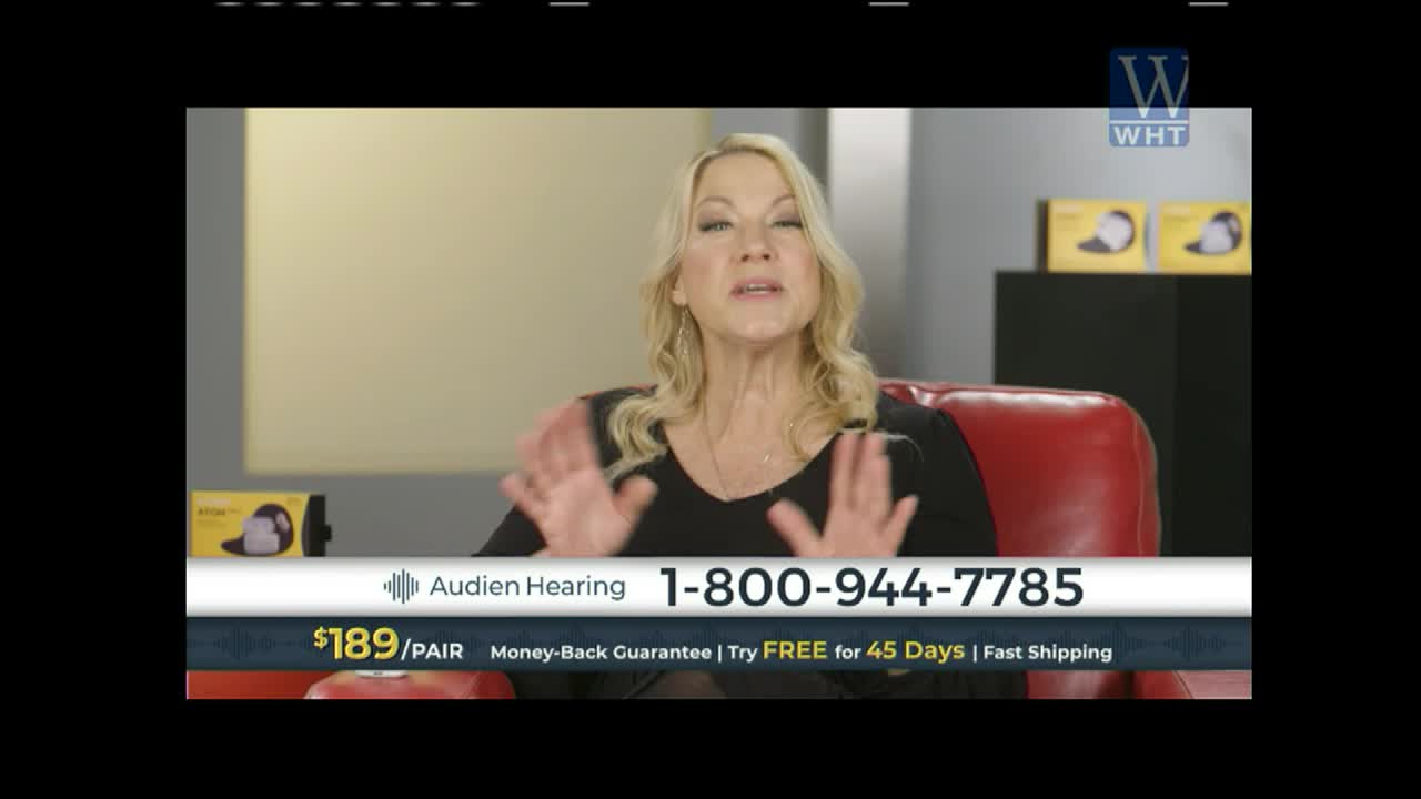 A woman with blonde hair is speaking animatedly, her hands held up in front of her. A graphic displays a phone number and the words "Audien Hearing" on screen.