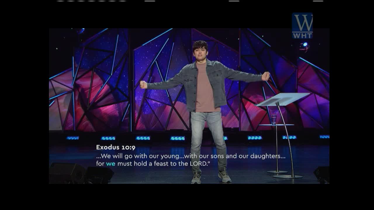 A young man stands with arms outstretched on a stage, speaking to an audience. The backdrop features geometric shapes and vibrant lighting, with the World Harvest Television logo visible.