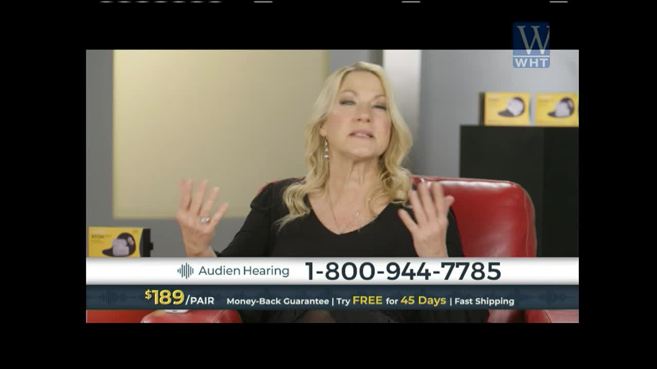 A woman with blonde hair gestures with both hands while speaking, her voice broadcast on World Harvest TV. A graphic at the bottom displays "Audien Hearing" and a phone number.