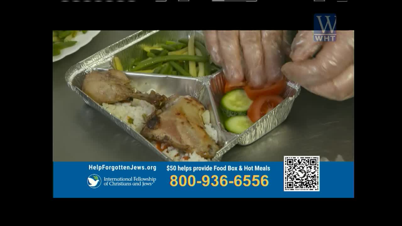 Gloves are carefully placing slices of tomato and cucumber into a foil container. This meal, prepared by the International Fellowship of Christians and Jews, is part of a World Harvest TV segment.