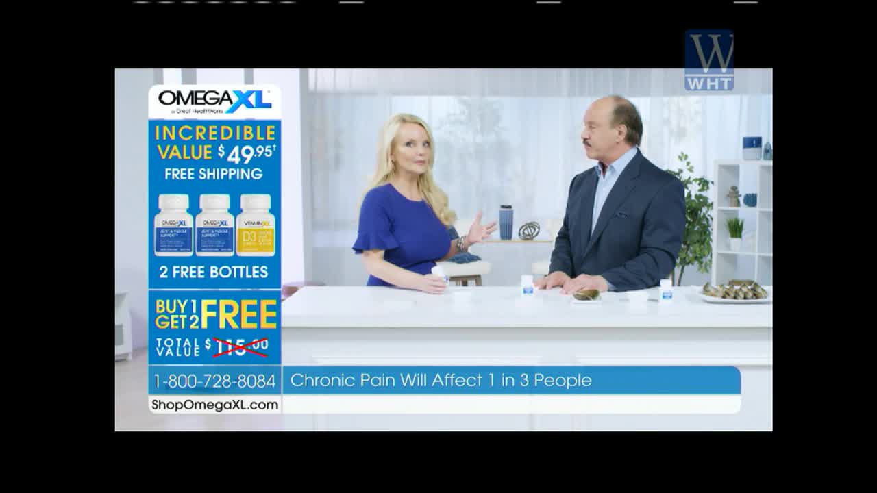 A woman in a blue dress gestures as she talks to a man in a suit, both standing behind a white counter. A large graphic on the left advertises OmegaXL, a product often featured on World Harvest TV.