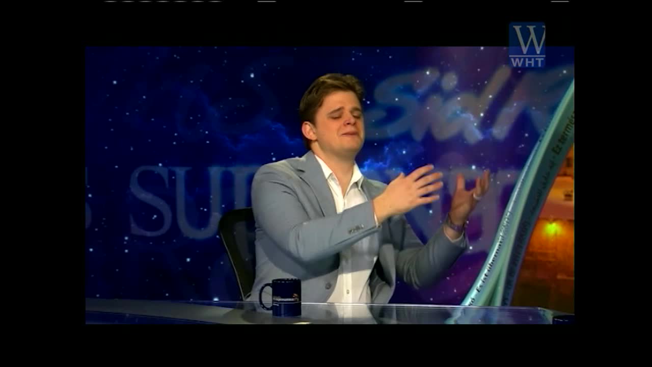 A man in a light gray suit jacket sits at a desk, his hands clasped and his face contorted in an emotional expression. The World Harvest TV logo is visible in the upper right corner.