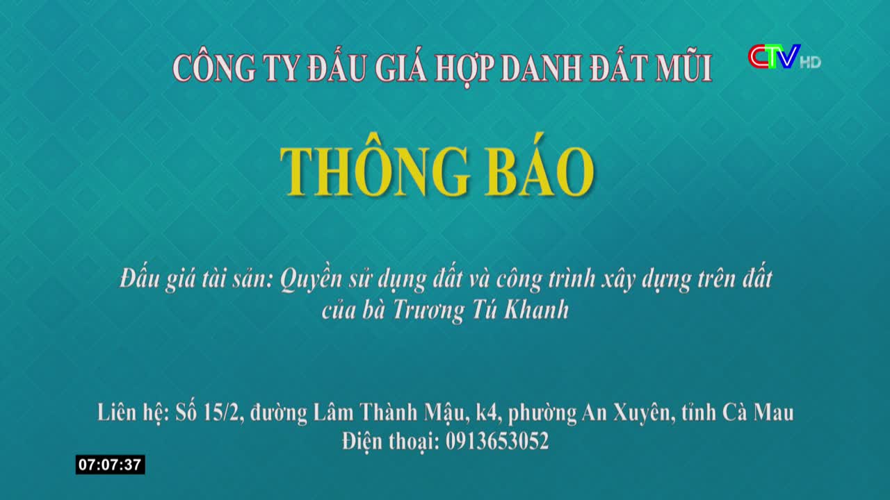 On the screen, bold yellow letters announce a notice from a company. Below, Vietnamese text describes the subject of an auction, with contact information and a timestamp at the bottom.
