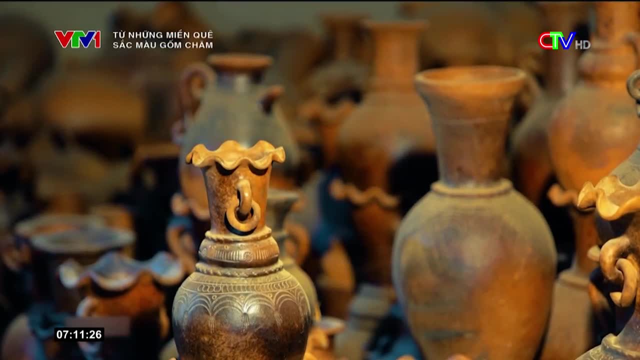 An array of earthenware vases, each with a unique shape and design, fills the frame.  The scene, likely from a Vietnamese broadcast, highlights the artistry of Cham pottery.

