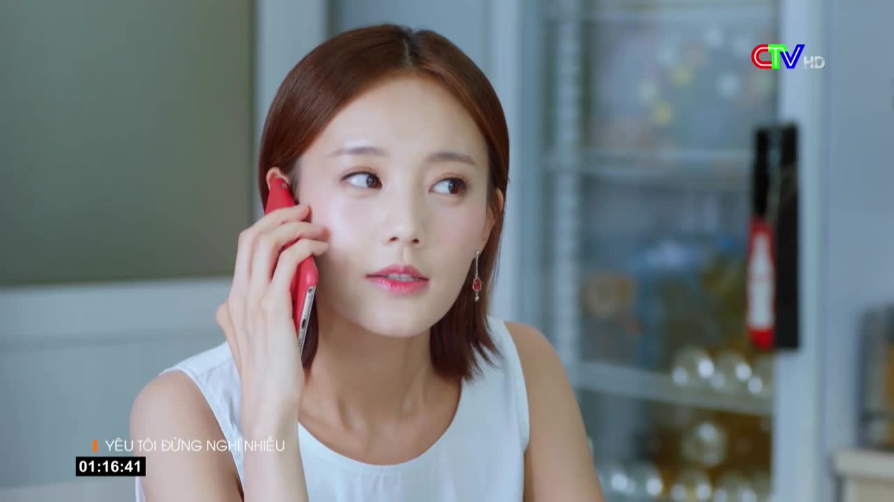 A woman with auburn hair holds a red phone to her ear, her gaze slightly off-camera. The Bac Lieu TV logo is visible in the corner, and the time is just past 1:16.
