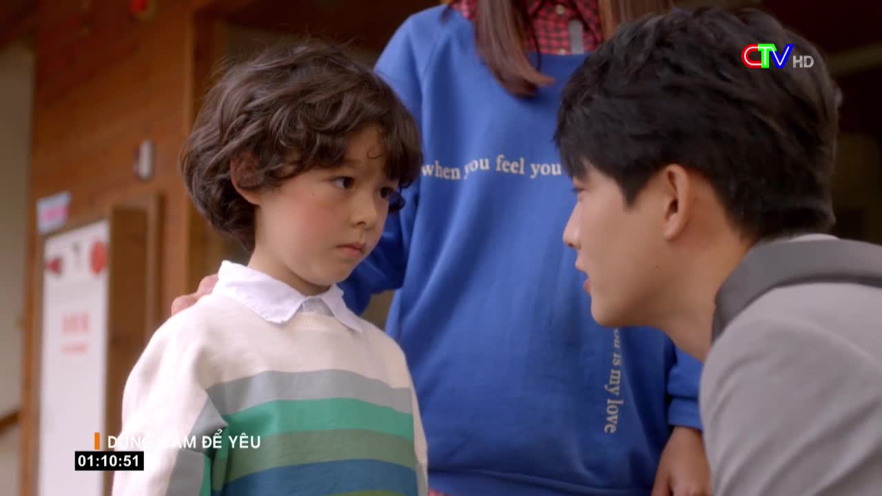 A young boy with curly hair stares intently at a man who is leaning in close. The man is speaking softly, his face filled with concern.
A young boy with curly hair stares intently at a man who is leaning in close. The man is speaking softly, his face filled with concern.